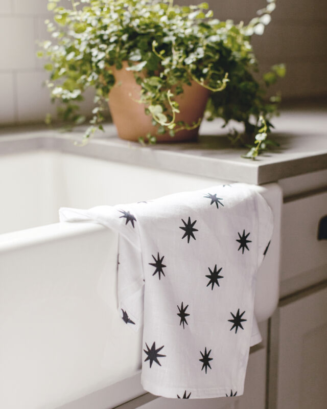 Our navy 8 Point Star tea towel is perfect for adding a festive touch to your kitchen sink this summer. This pattern was inspired by vintage quilt block stars and gives nod to a classic Americana summer. #linenteatowel #designerfabric